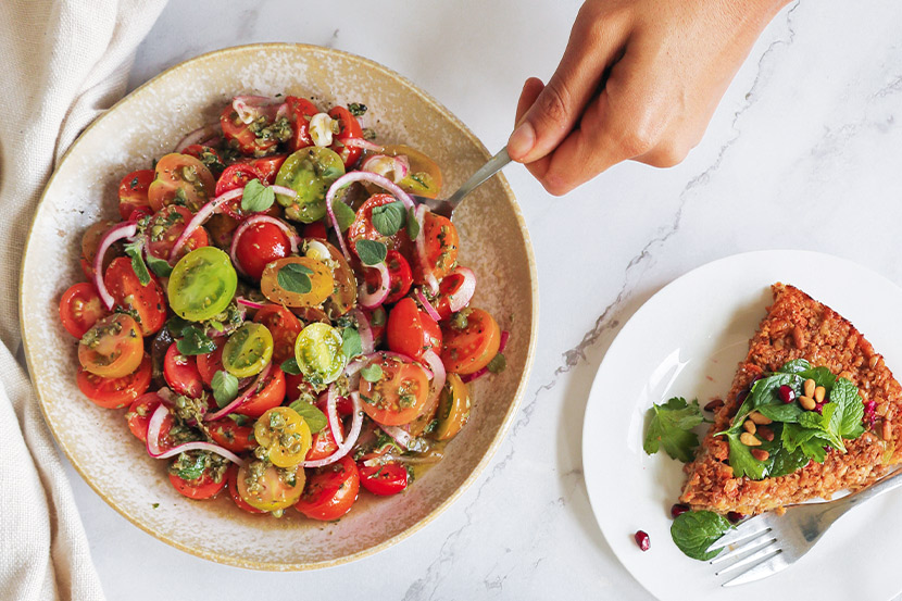 Bowl full of Tomato salad with caper and oregano dressing